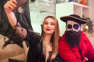 vrolijk piraat en vampier vrouw Bij halloween partij nemen een selfie. foto