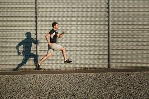 vol lengte portret van atletisch Mens rennen foto