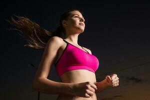 rennen vrouw. loper jogging in avond. foto