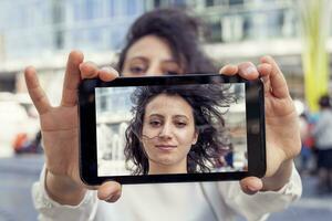 mooi jong vrouw nemen een selfie met slim telefoon foto