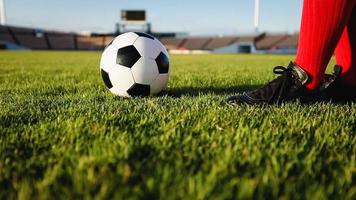 voetbal of voetballer die met de bal op het veld staat om de voetbal in het voetbalstadion te schoppen