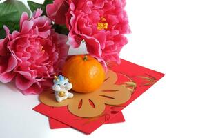 Chinese nieuw jaar van de draak festival concept. oranje, rood enveloppen, twee draken en goud baar versierd met Pruim bloesem Aan wit achtergrond. kopiëren ruimte voor tekst. foto