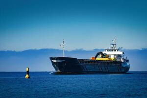 zwart het zeilen bulk vervoerder. lading schip met lang bereiken graafmachine in beweging in nog steeds water Bij zonnig dag door de zee foto