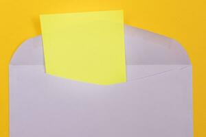 paars envelop met blanco geel vel van papier binnen, aan het liegen Aan geel achtergrond bespotten omhoog met kopiëren ruimte. ontvangen mail of merk op, Bezig met verzenden ansichtkaart top visie, vlak leggen foto
