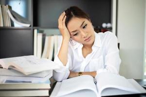 Aziatische zakenvrouw en vrouwelijke student serieus over het leesboek en hard werken tot de hoofdpijn foto