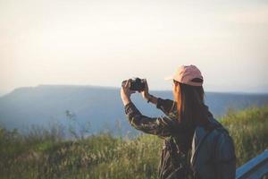 Aziatische jonge vrouwen wandelen met vrienden rugzakken samen wandelen en kaart kijken en fotocamera nemen langs de weg en er gelukkig uitzien, ontspannen tijd op vakantie concept reizen foto