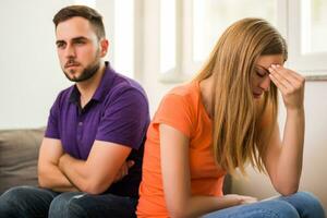 boos vrouw en man zijn hebben conflict terwijl ze zittend Aan sofa Bij hun huis. foto