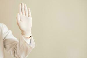 beeld van dichtbij omhoog hand- in beschermend handschoen van dokter tonen hou op teken foto