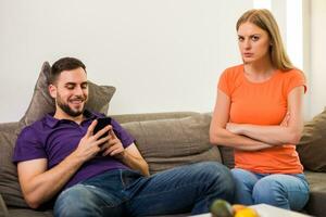 boos vrouw en man zijn hebben conflict omdat man is gebruik makend van telefoon te veel. foto