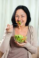vrouw geniet aan het eten salade foto
