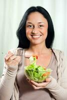 vrouw geniet aan het eten salade foto