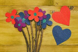 beeld van bloemen met twee hart vormen Aan houten tafel.afgezwakt foto. foto