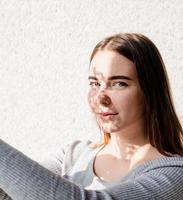 portret van een mooie jonge vrouw met een schaduwpatroon op het gezicht en lichaam in de vorm van bloemen foto