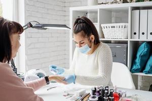 manicure meester met behulp van een elektrische machine om de nagellak te verwijderen tijdens manicure in de salon foto