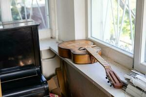 oud stoffig gitaar in een oud huis. net dreadnought akoestisch gitaar. gitaar Aan achtergrond. foto