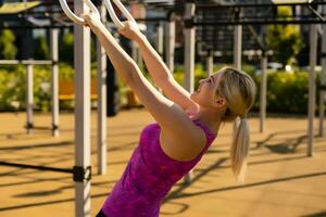 geschiktheid vrouw aan het doen sit ups in buitenshuis Sportschool wakker worden uit sterkte opleiding foto