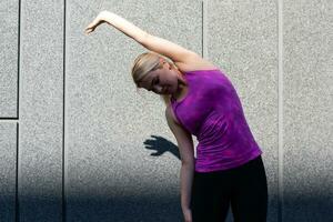 geschiktheid sport vrouw in mode sportkleding aan het doen yoga geschiktheid oefening in de straat, buitenshuis sport, stedelijk stijl foto