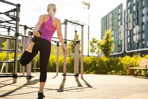 geschiktheid sport vrouw in mode sportkleding aan het doen yoga geschiktheid oefening in de straat, buitenshuis sport, stedelijk stijl foto