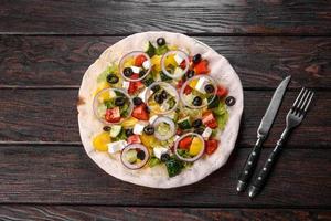 smakelijke verse Griekse salade op een pitabroodje gekookt voor een feestelijke tafel foto