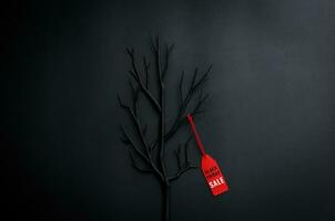 zwart boom met takken met woord Bij rood prijs label Aan donker achtergrond voor zwart vrijdag boodschappen doen uitverkoop concept. foto