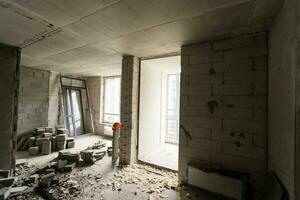 muur verpletterd in puin kamer in appartement klaar voor vernieuwing met vernietigd verpletterd muur slopen foto