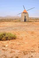 een windmolen in de midden- van een dor veld- foto