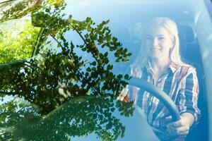 zelfverzekerd en mooi. aantrekkelijk jong vrouw in gewoontjes slijtage het rijden een auto foto