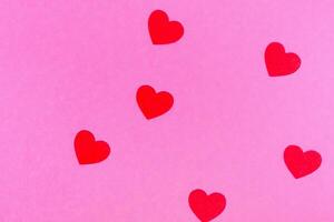 rood harten Aan een roze achtergrond voor een groet kaart of banier voor Valentijnsdag dag. foto