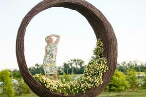 mooi jong vrouw in mooi hoor jurk poseren Aan kleurrijk muur van bloemen. mode foto, mooi hoor haar, groot glimlach foto