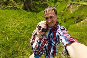 twee wandelaars nemen selfie Aan top van de berg foto