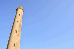 de hoog toren van een moskee tegen een blauw lucht foto