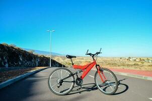 een rood fiets geparkeerd Aan de kant van de weg foto