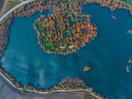 luchtfoto van herfstbos met meerhemel weerspiegeld in water foto