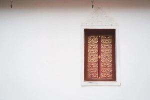 venster op de muur van tempel wat phra that khao noi, nan provincie, thailand foto