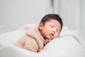 schattige pasgeboren baby die vredig op een witte deken slaapt foto