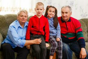 grootouders en hun jong kleinkinderen ontspannende Bij huis foto