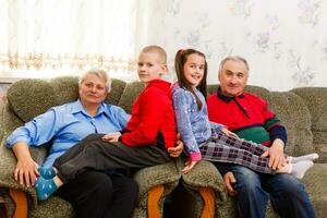 grootouders en hun jong kleinkinderen ontspannende Bij huis foto