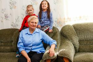 gegroeid omhoog volwassen glimlachen kleinkinderen omarmt ouderen grootmoeder blij naar zien missend haar, bezoek van liefhebbend familieleden genieten communicatie, knuffelen net zo symbool van verbinding, liefde en ondersteuning concept foto