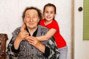 vrolijk jong meisje nemen zorg van een ouderen vrouw Bij huis foto