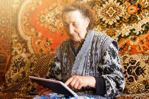 senior vrouw browsen Aan digitaal tablet foto