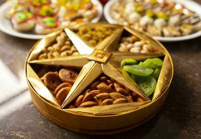 Indisch traditioneel mengen snoepgoed voedsel geserveerd in speciaal decoratief bord Aan wijnoogst achtergrond foto