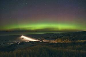 Aurora borealis over- de strand Bij Deens kust foto