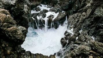 een waterval is vloeiende naar beneden een rotsachtig klif foto