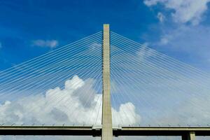 de brug overspanningen over- de water en heeft een groot kabel foto