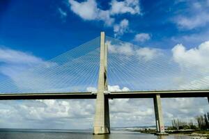 de brug overspanningen over- de water en heeft een groot kabel foto