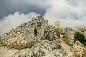 de ruïnes van een oud kasteel in de bergen foto