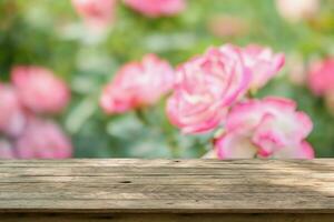 leeg hout tafel top met vervagen roos tuin achtergrond voor Product Scherm foto