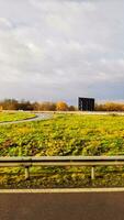 kronkelend weg naast veld- van geel groen gras foto