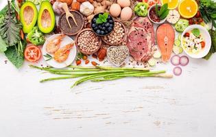 ketogeen koolhydraatarm dieetconcept. ingrediënten voor gezonde voeding selectie opgezet op witte houten achtergrond. foto