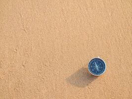 kompas Aan strand zand achtergrond. de concept van wereld toerisme dag, zoeken de Rechtsaf routebeschrijving en reizen foto